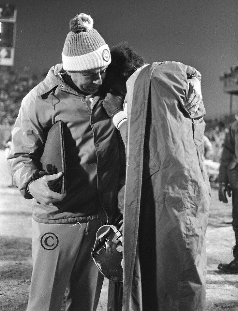 Retiring running back Floyd Little is overcome with emotions during the final minutes of his last home game. He buries his head on head coach John Ralston's shoulder.